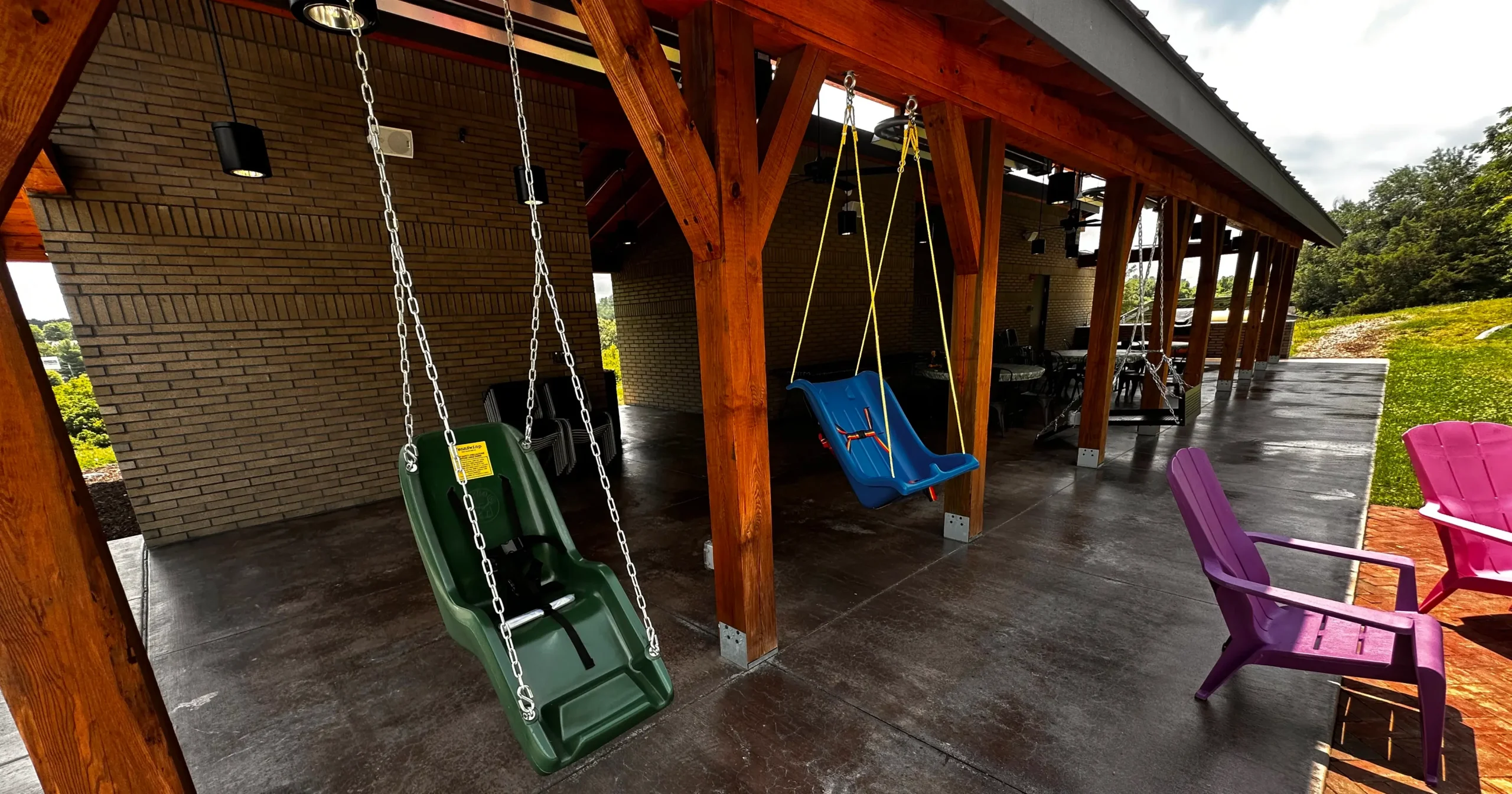 Two accessible swings on the porch of Trinity Grace Farm